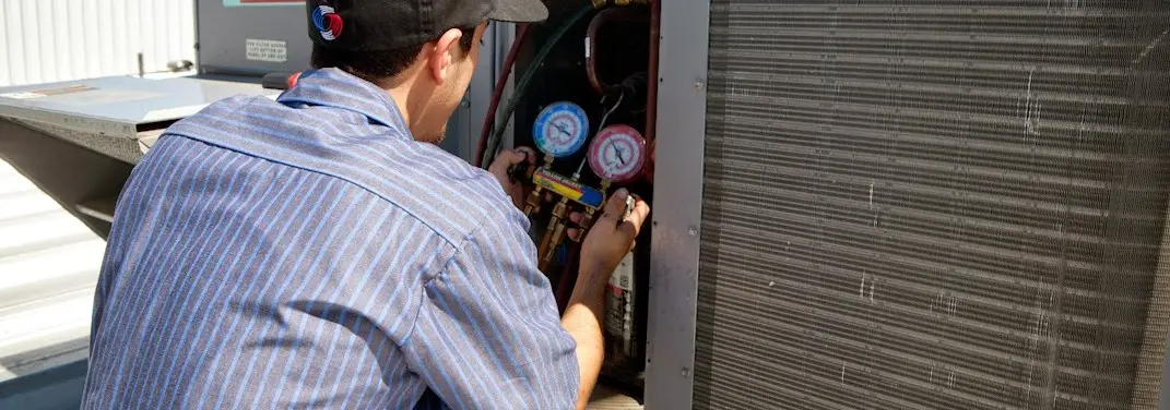 HVAC technician servicing a condenser unit in Middle Paxton